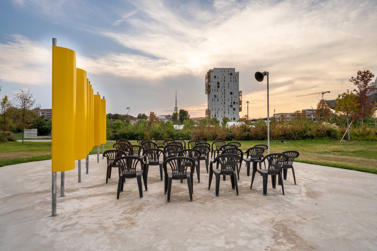 Liliana Moro, Sundown, 30 bronze chairs, metal panel, acoustic trumpet, speaker with connection to RADIO 3, 2023. Installation view, ArtLine Sculpture Park, Milan, 2023