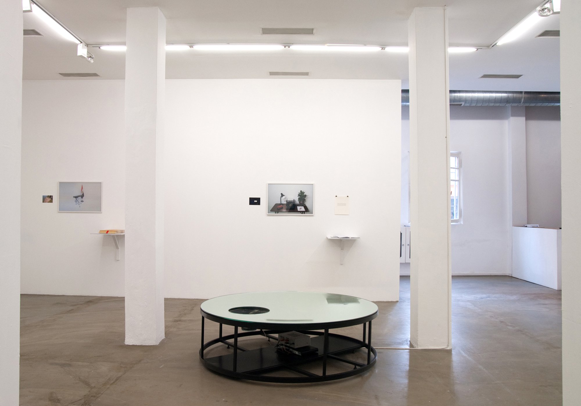 (Centre) Can Altay, Deposit (Spring Deficit: After Dubai, After Hammons and after the politics of white noise), 2010. (On wall) Iman Issa, Triptych #4, photographs, text, notebooks, dimensions variable, 2009Installation view, Can Atlay – Iman Issa, Rodeo, Istanbul, 2010